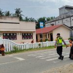 Personel Polsek Trumon Timur Sigap Bantu Siswa Menyeberang Jalan